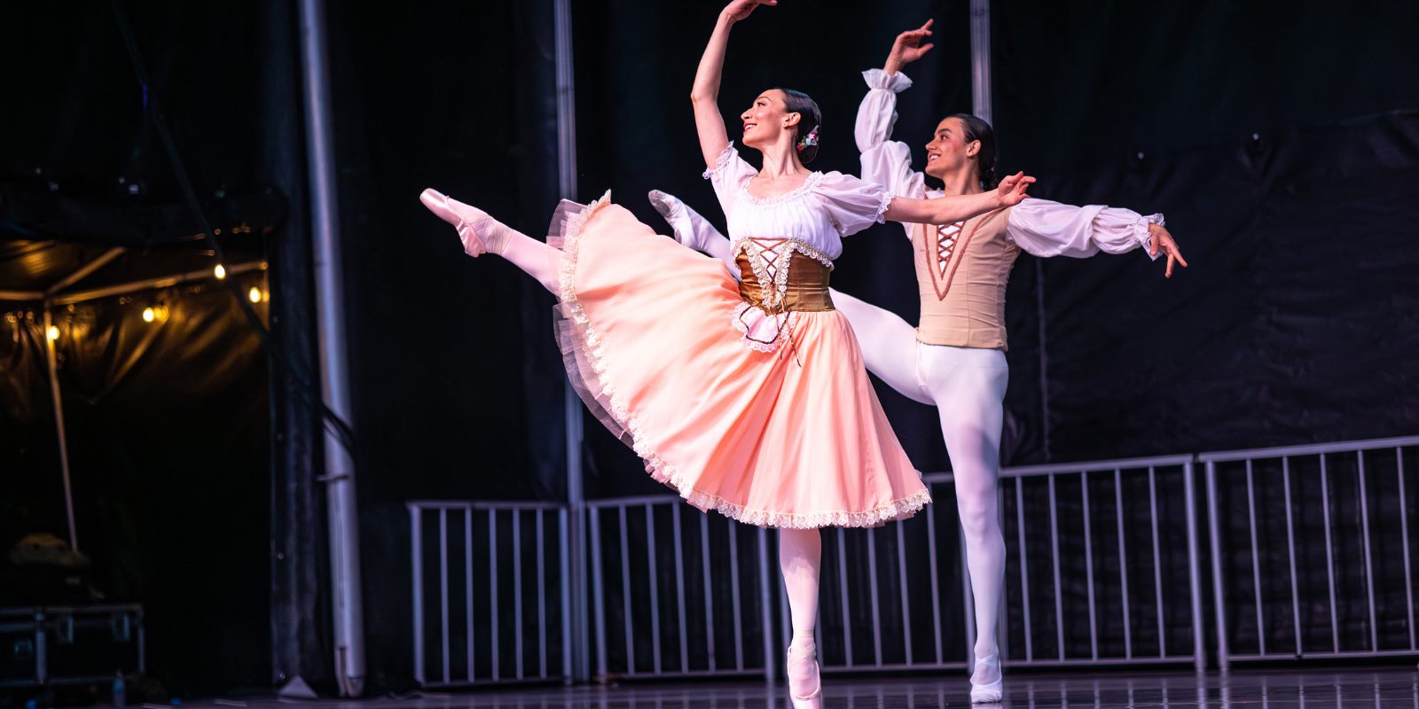 Members of First State Ballet perform on stage in white tutus and small crowns.